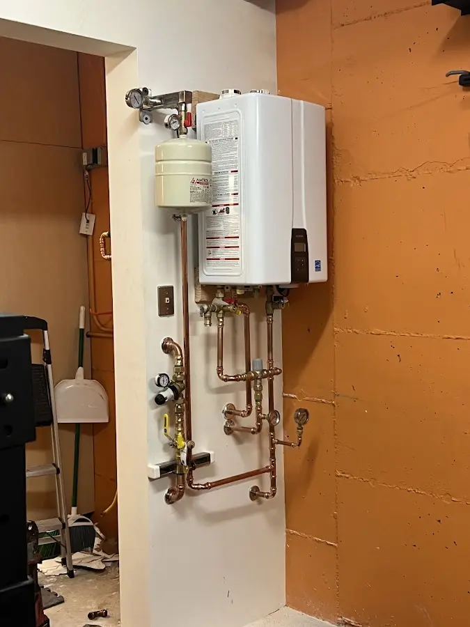 Plumbing technician inspecting water heater connections in Mustang